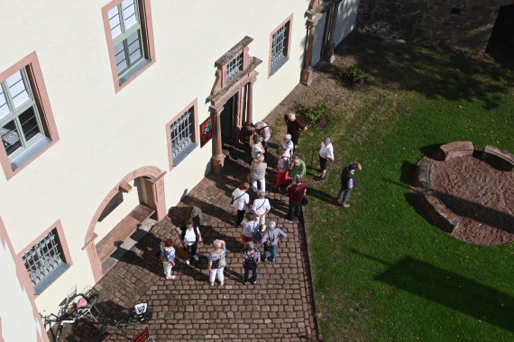 Vogelperspektive auf eine Gruppe Erwachsener, die vor der Eingangstür des Museums steht.