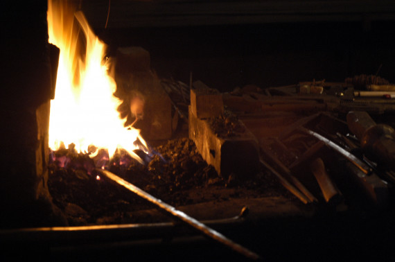 Feuer in einer Esse des Eisenhammers in Hasloch. Rechts im Dunkeln erahnt man Werkzeuge eines Schmieds